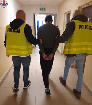 policjanci prowadzą zatrzymanego mężczyznę
