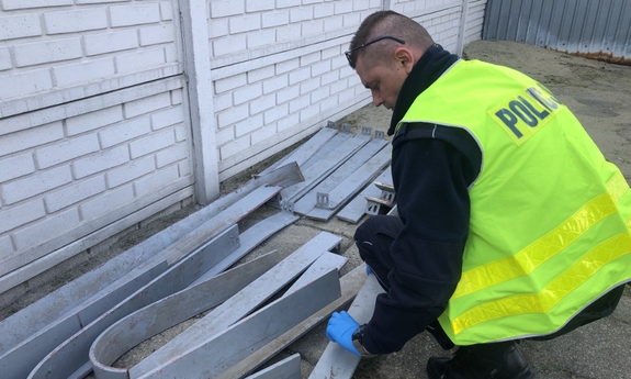 policjant podczas oględzin metalowych elementów