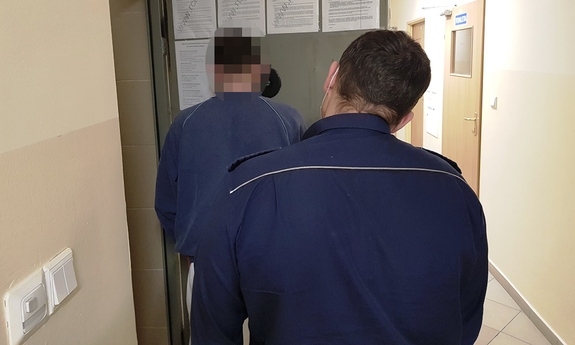 policjanci prowadzą zatrzymanego mężczyznę