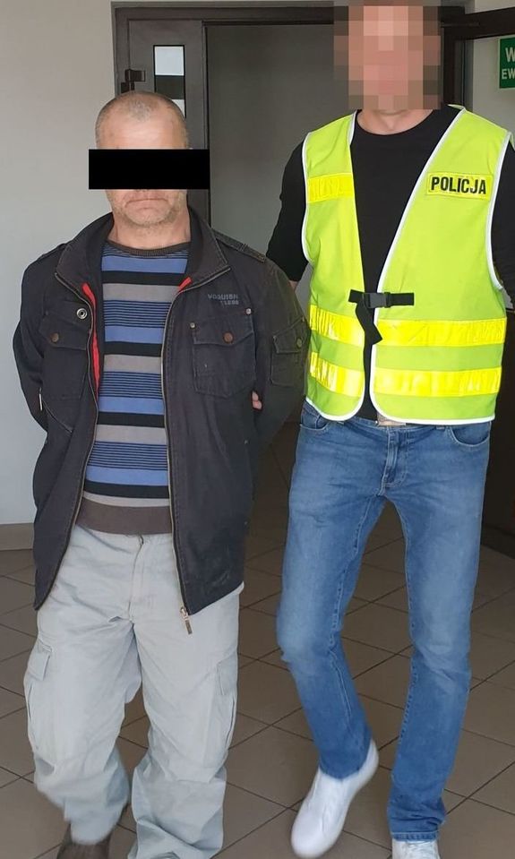 Zdjęcie przedstawia policjanta ubranego w seledynową odblaskową kamizelkę, który prowadzi zatrzymanego mężczyznę. Twarz policjanta jest zasłonięta komputerowym filtrem. Twarz mężczyzny zasłania czarny prostokąt.