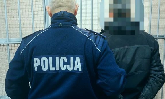 umundurowany policjant wraz z zatrzymanym mężczyzną