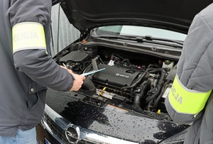 przód samochodu z otwartą maską, przed nim stoją dwaj policjanci