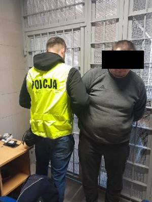 policjant prowadzi zatrzymanego mężczyznę