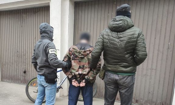 dwaj policjanci z zatrzymanym mężczyzną