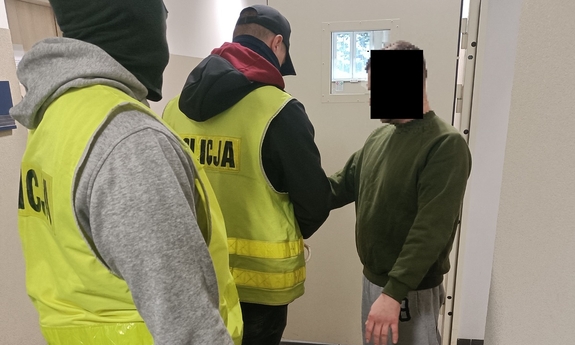 dwaj policjanci z zatrzymanym mężczyzną