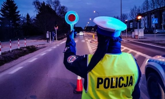 Policjant na drodze z policyjnym lizakiem w dłoni