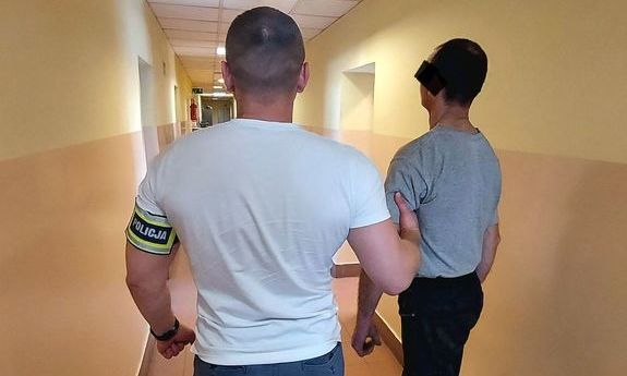 policjant prowadzi zatrzymanego mężczyznę