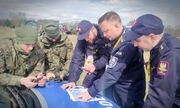 Policjant, Straż Ochrony Kolei i żołnierze sprawdzają mapy na masce pojazdu