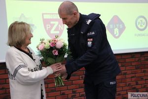 zastępca komendanta głównego Policji wręcza bukiet kwiatów Pani Prezes Fundacji PZU