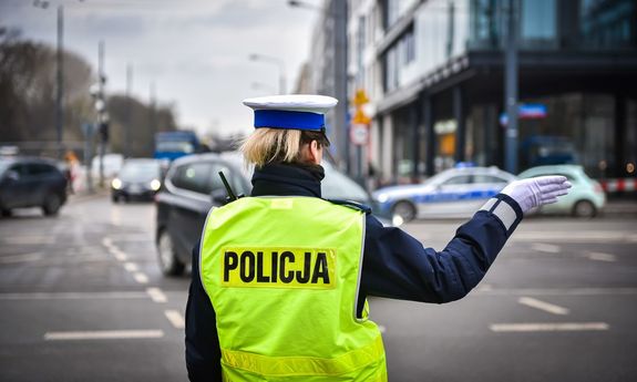 Zdjęcie przedstawia umundurowaną policjantkę kierującą ruchem.