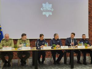 prelegenci siedzący za stołem prezydialnym