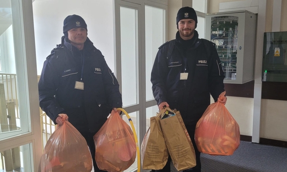 policjanci w domu dziecka z workami z prezentami