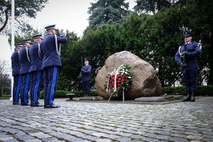 Komendant Główny Policji wraz z trzema zastępcami oddają hołd poległym przed obeliskiem „Poległym Policjantom - Rzeczpospolita Polska” salutując. Przy pomniku stoi warta honorowa