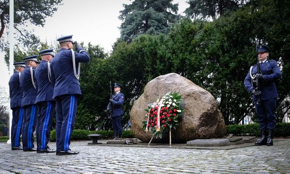 Komendant Główny Policji wraz z trzema zastępcami oddają hołd poległym przed obeliskiem „Poległym Policjantom - Rzeczpospolita Polska” salutując. Przy pomniku stoi warta honorowa