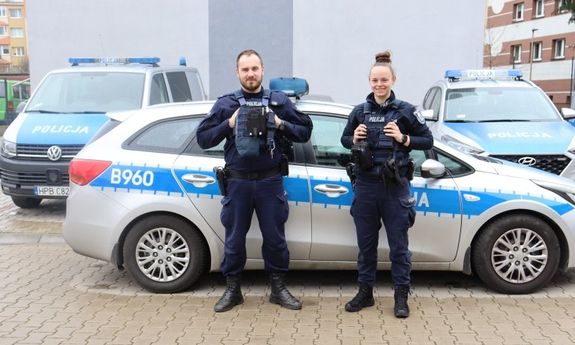 funkcjonariusze wydziału prewencji Piotr Czycz i Karolina Kaźmierska na tle trzech radiowozów