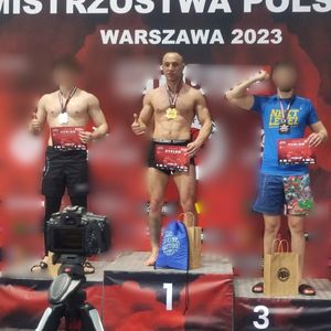 Zdjęcie przedstawia trzech mężczyzn stojących na podium.