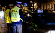 dwaj policjanci stoją przy taxi podczas kontroli