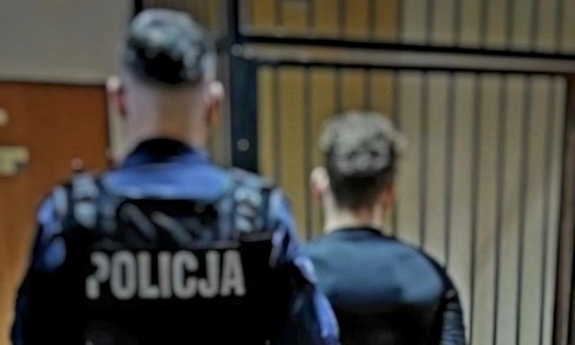 policjant z zatrzymanym zakutym w kajdanki