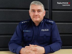 policjant siedzi za biurkiem w umundurowaniu