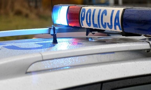 Zdjęcie przedstawia fragment oznakowanego radiowozu z lampą na dachu.