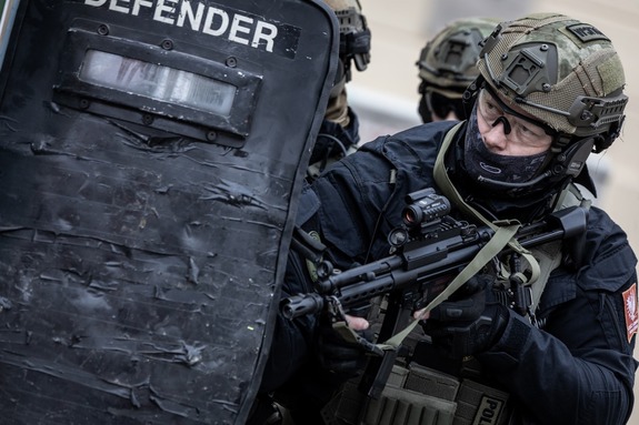 umundurowany policjant  z tarczą