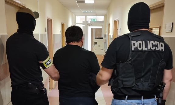 dwaj policjanci prowadzą zatrzymanego