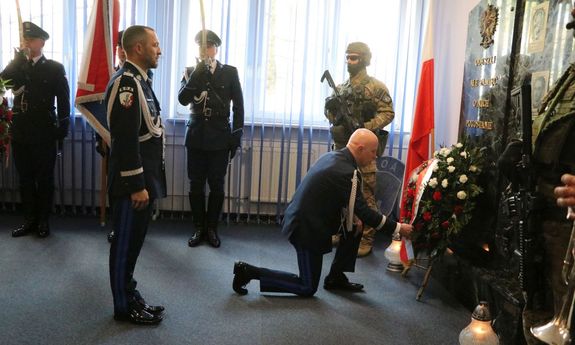 uroczystość w CPKP BOA upamiętniająca śp. Piotra Molaka, który zginął na służbie - Komendant Główny Policji przyklęka przed tablicą pamięci