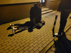 policjanci z zatrzymanym mężczyzną w kajdankach