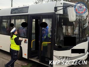 policjantka ruchu drogowego stoi przed wejściem do autobusu