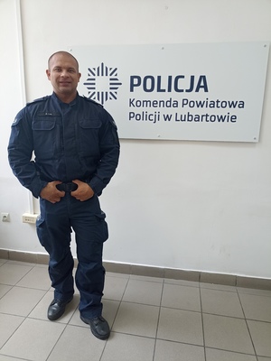 Policjant stoi przy napisie Komenda Powiatowa Policji w Lubartowie