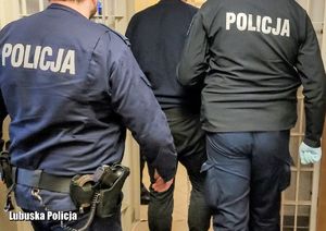 policjanci prowadzą zatrzymanego mężczyznę