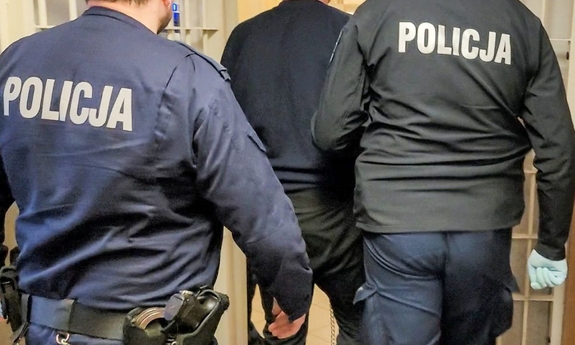 policjanci prowadzą zatrzymanego mężczyznę