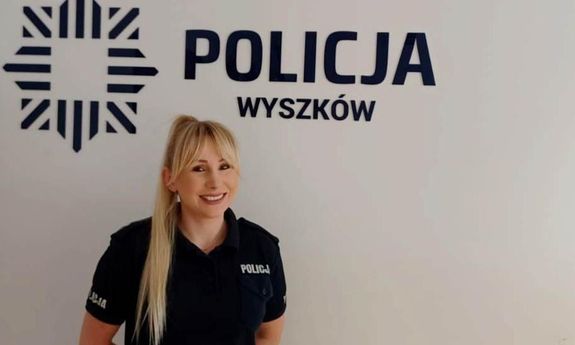 policjantka stojąca na tle napisu Policja