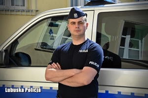 policjant stoi przy radiowozie