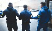 dwaj nieumundurowani policjanci prowadzą zatrzymanego