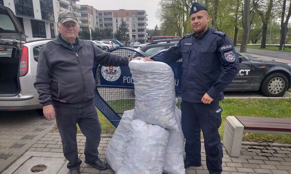 przekazanie nakrętek w tle budynek komendy i pojazdy