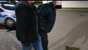 policjant prowadzi zatrzymanego