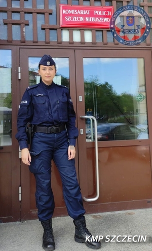 umundurowana policjantka stoi przed budynkiem Komisariatu Policji