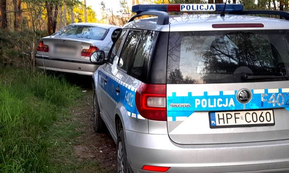 Policyjny radiowóz, przed nim stojący pojazd bmw