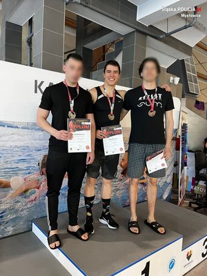 trzej młodzi ludzie z medalami na podium