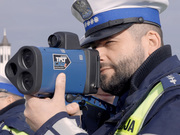 policjant ruchu drogowego trzyma w ręku laserowy miernik prędkości z rejestracją obrazu
