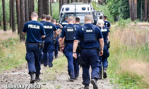 policjanci idą przez las