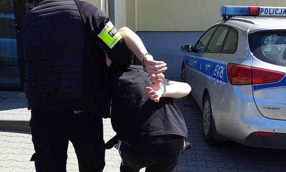 policjant prowadzi podejrzanego