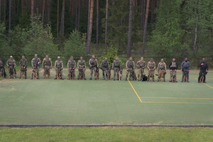 kontrterroryści z psami bojowymi ustawieni w jednej linii na polanie