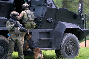 kontrterroryści z psem przy wozie bojowym