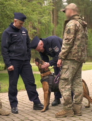 policjanci głaskają psa