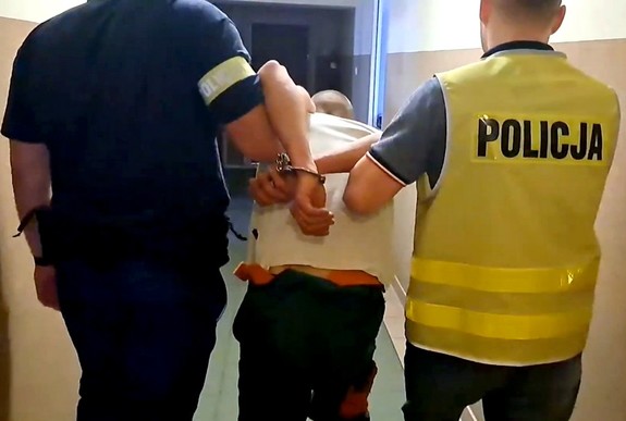 Dwóch policjantów prowadzi zatrzymanego