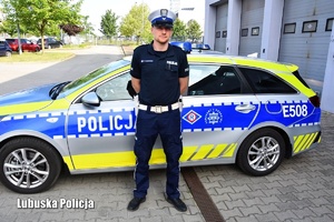 Policjant ruchu drogowego przed radiowozem