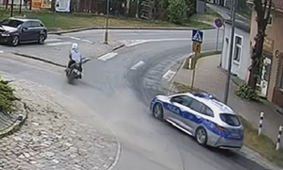 radiowóz jedzie za motocyklem na rondzie