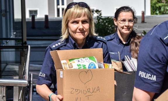 dwie policjantki, jedna z nich trzyma karton
